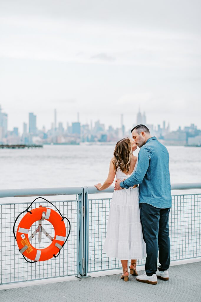 A couple awaiting the ferry to Manhattan during their Jersey City Waterfront engagement session photo