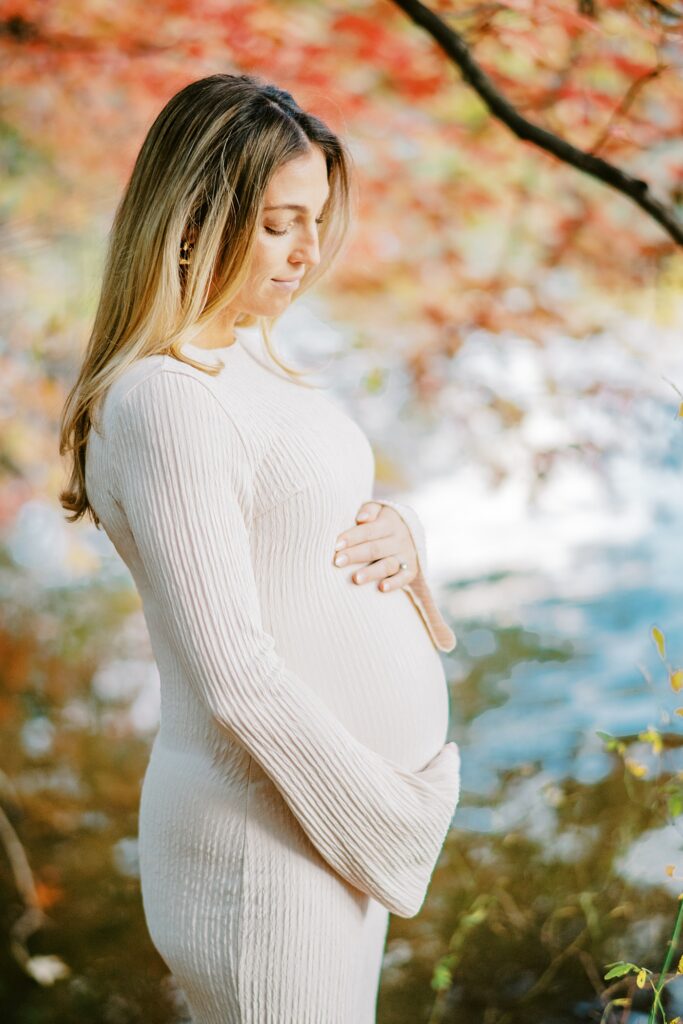Expectant mother in neutral knit dress during fall maternity portraits in NYC.