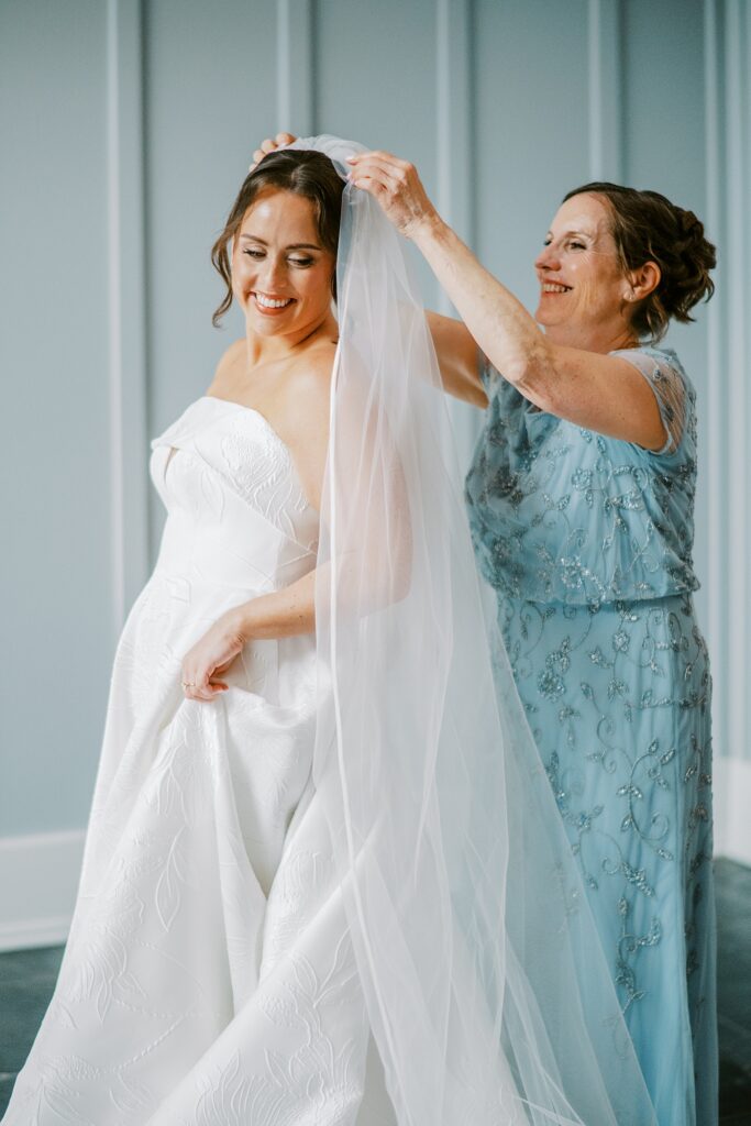 Bride getting ready with her mother placing veil at Chesapeake Bay Beach Club wedding in Maryland